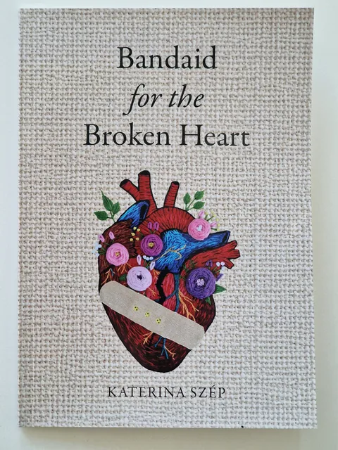 Bandaid for the Broken Heart by Katerina Szép — the book cover, an embroidered anatomical heart surrounded by flowers on linen